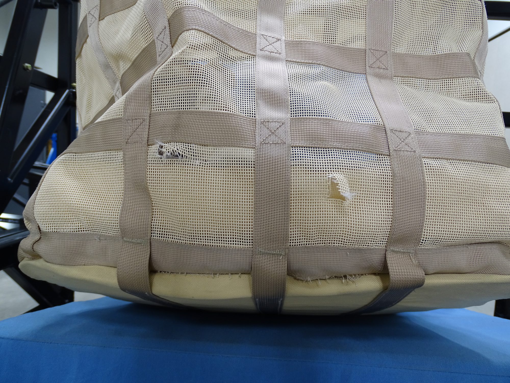 Detail close-up of the quilted shell after the crash, weave still tight.